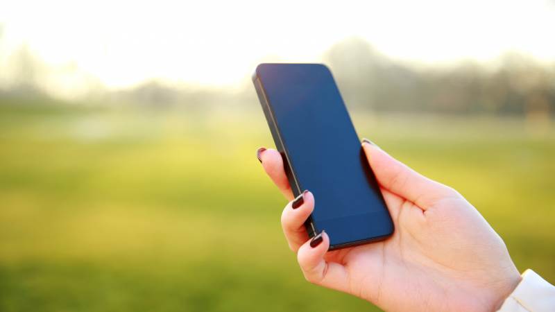 En mobiltelefon hålls i en hand.