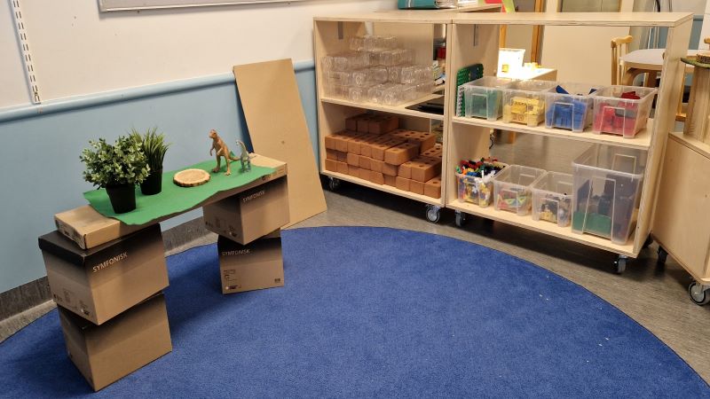 Bokhylla med byggmaterial och ett bygge av klossar