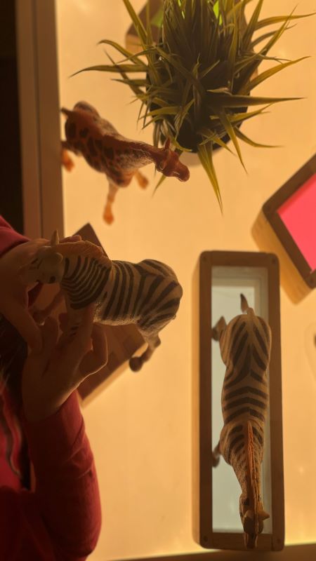 Barn leker med djur på ljusbord