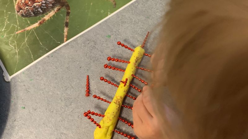 Barn skapar en spindel i lera efter en bild