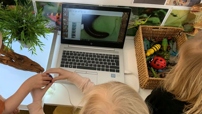 Barn undersöker en mask med digitala verktyg